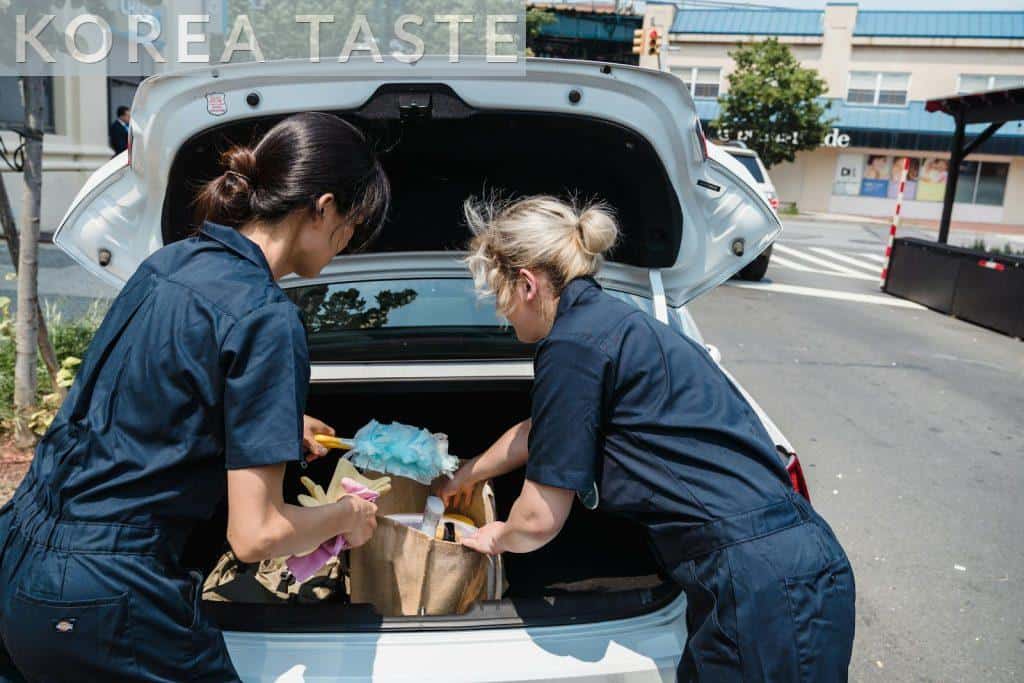 Women Taking out Their Cleaning Tools from a Car Trunk