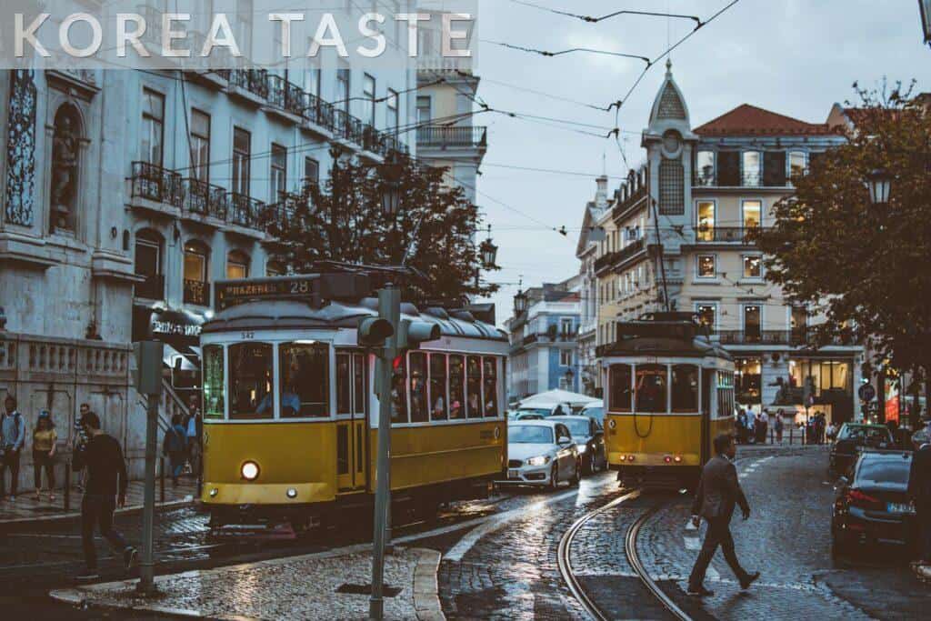 Scenic view of trams navigating the charming streets of Lisbon at dusk, capturing urban life and transportation.