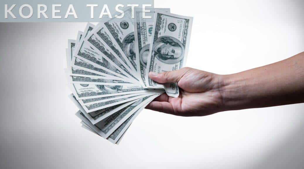 person holding 100 US Dollar banknote