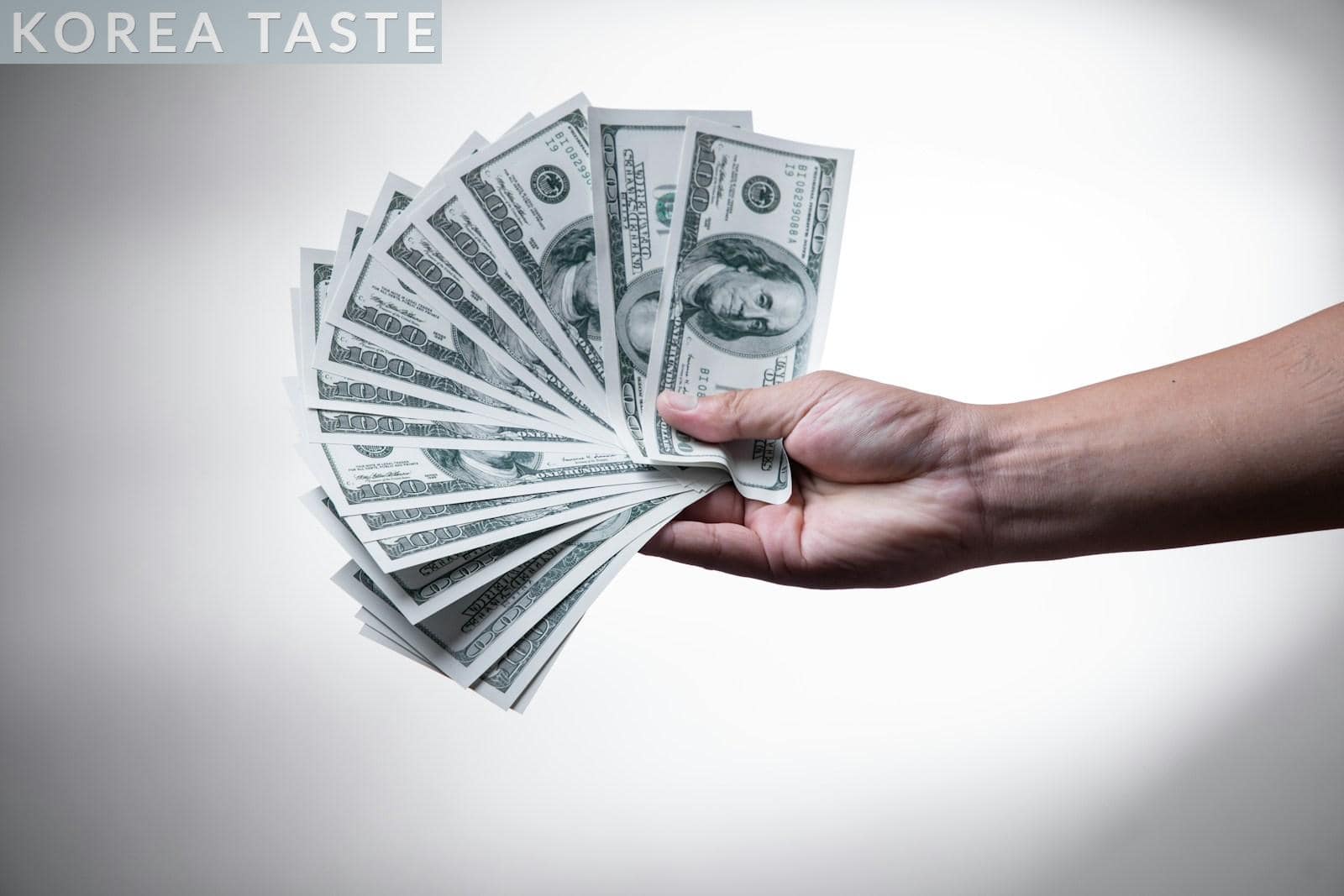 person holding 100 US Dollar banknote